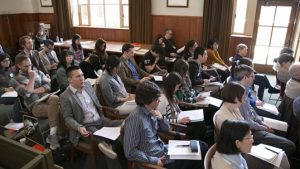 A seminar room filled with people engaged in a discussion